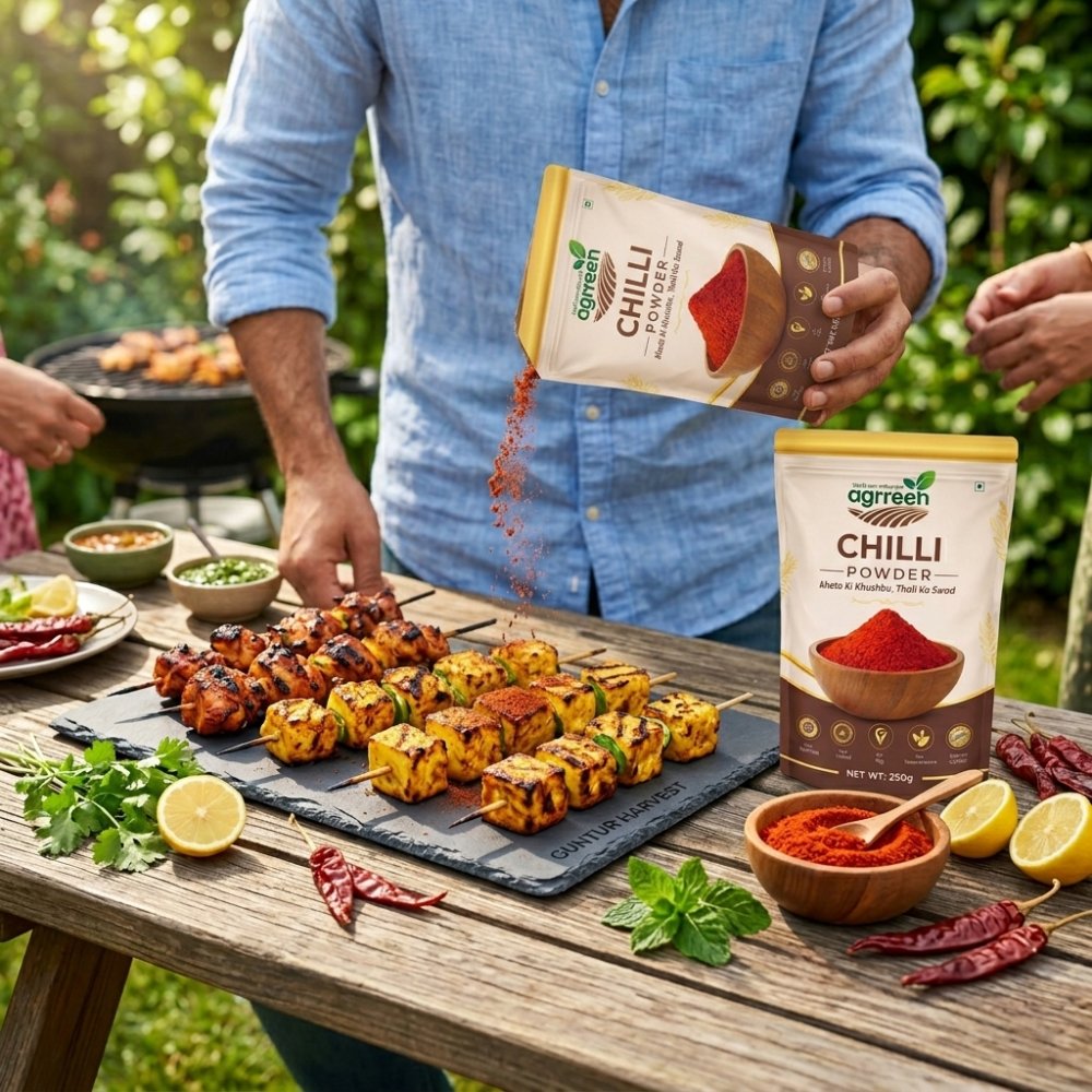 AGRREEN Guntur Chilli Powder pack on an outdoor table, being sprinkled over grilled paneer and chicken skewers